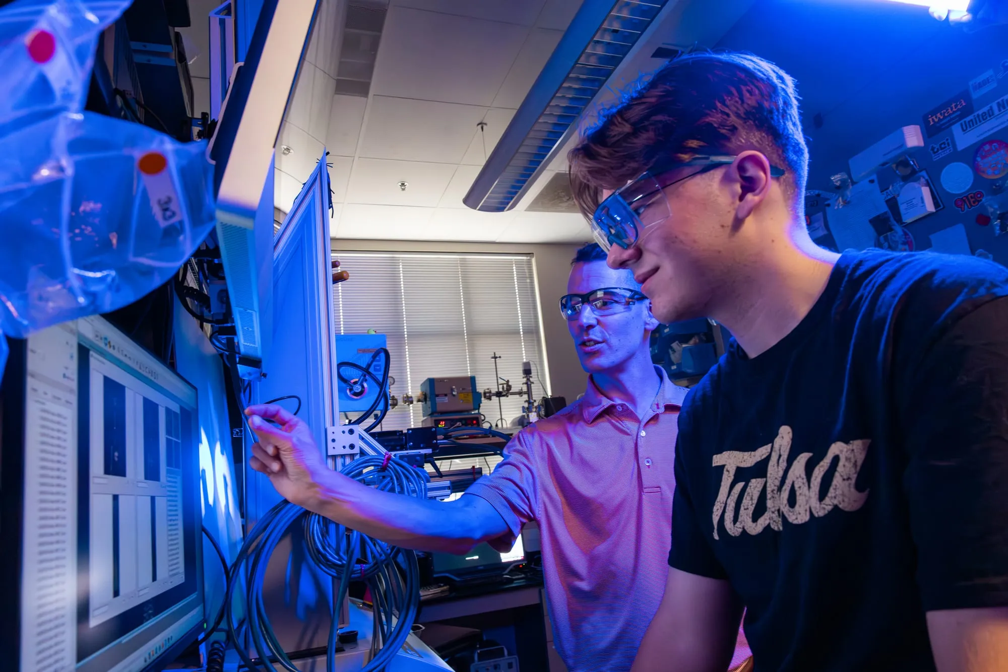 An AMDG member and Prof. LePage review digital image correlation software output on a lab monitor.